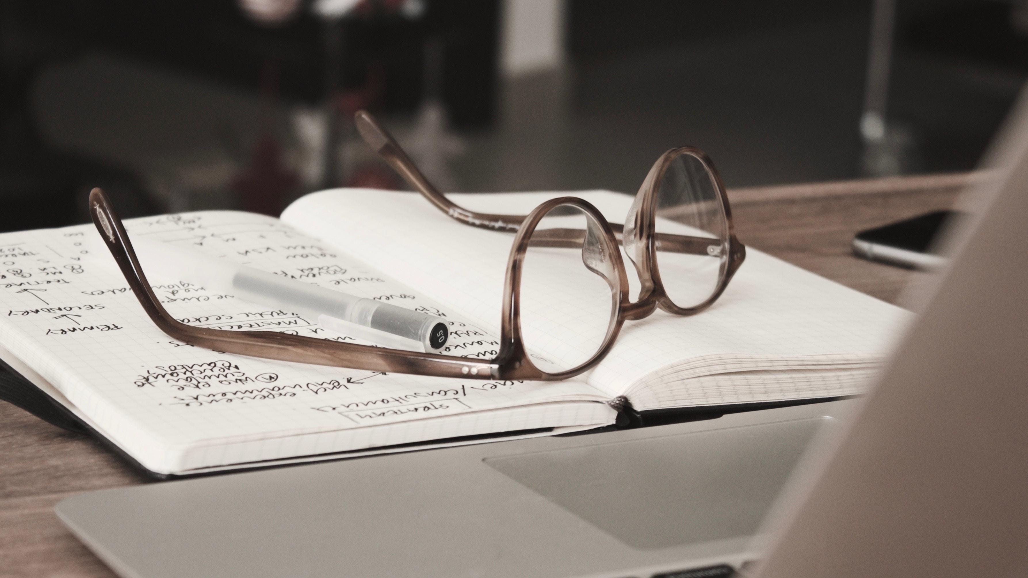 notebook with glasses and pen